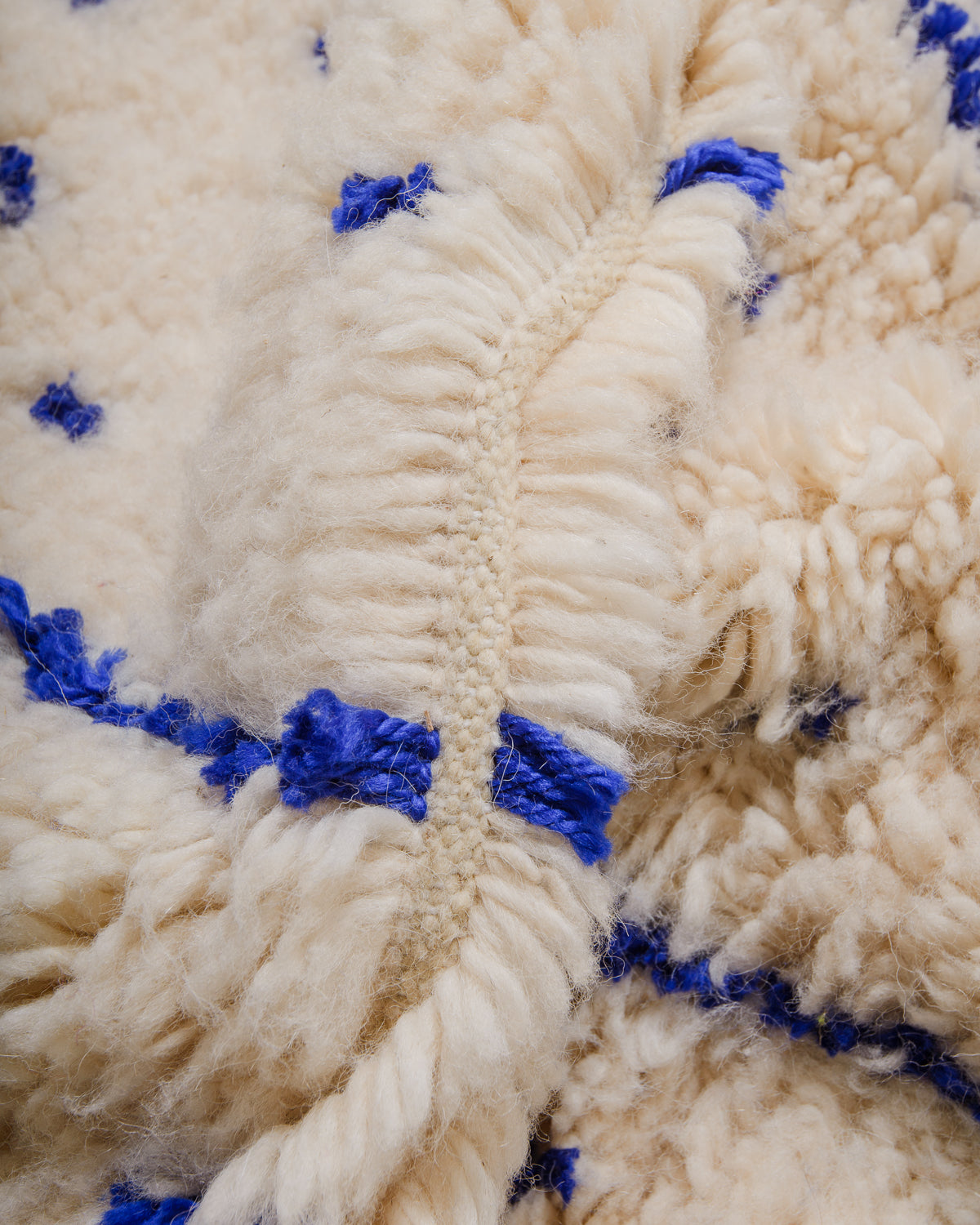 Detail of Azilal rug showing the fluffy wool, soft blue cotton and the spacing between the rows.