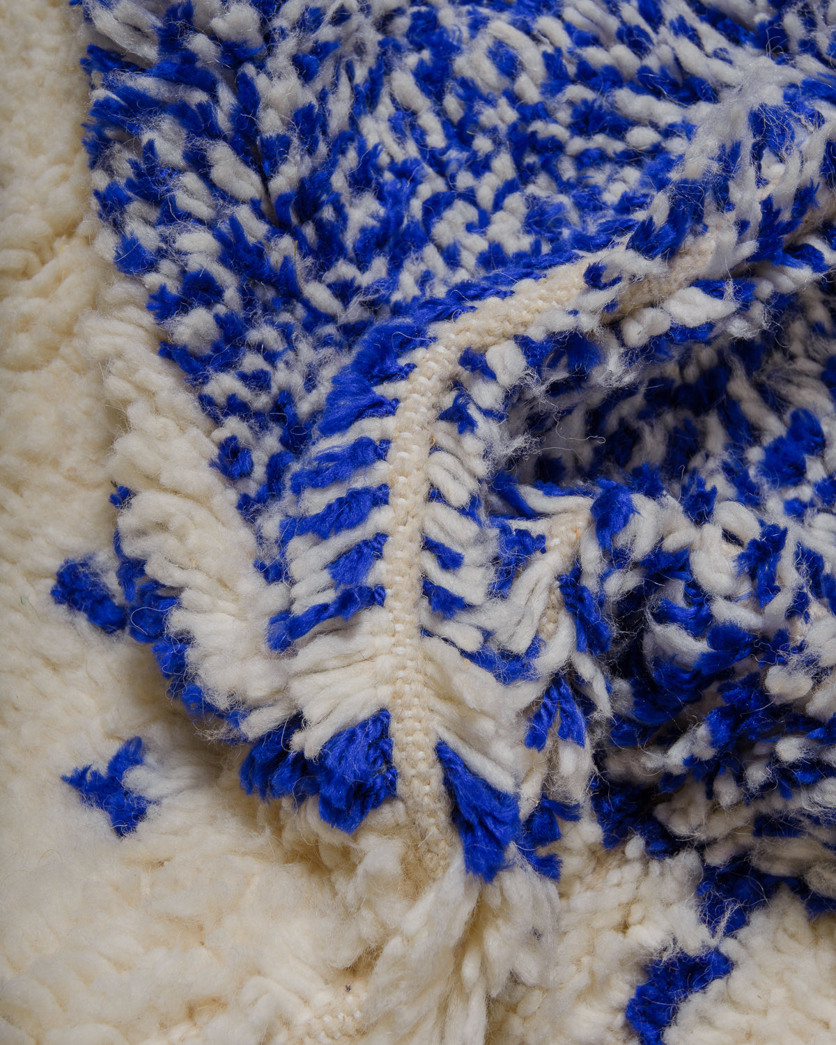 Close up of Azilal rug showing the fluffy wool, soft blue cotton and the spacing between the rows.