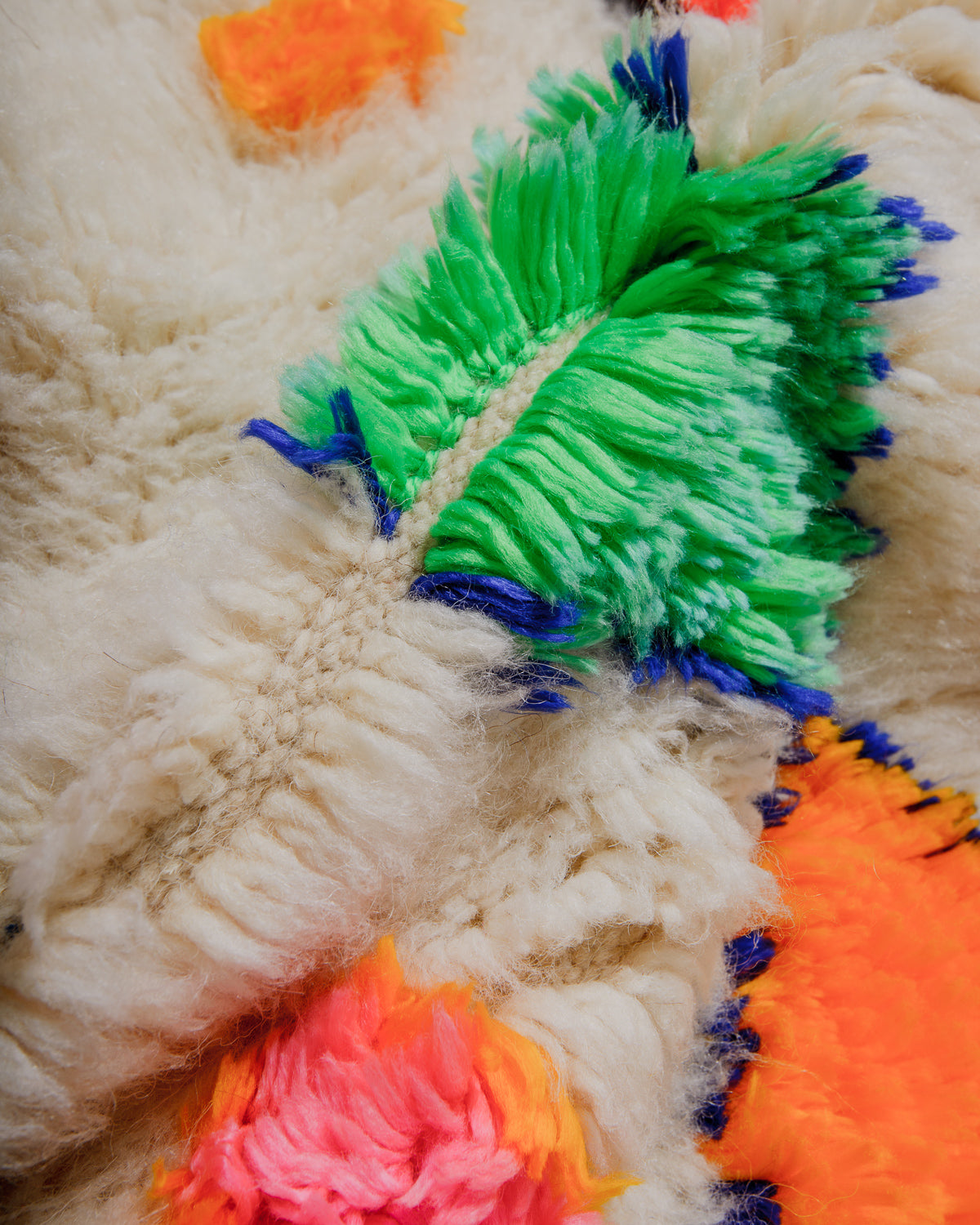 Close-up of a textured wool rug with colourful yarn accents