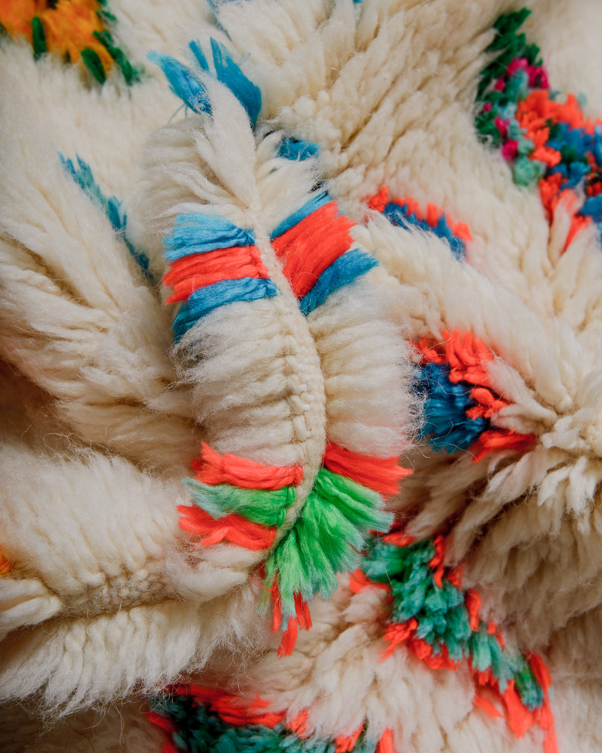 Close-up of a wool rug with colourful yarn accents
