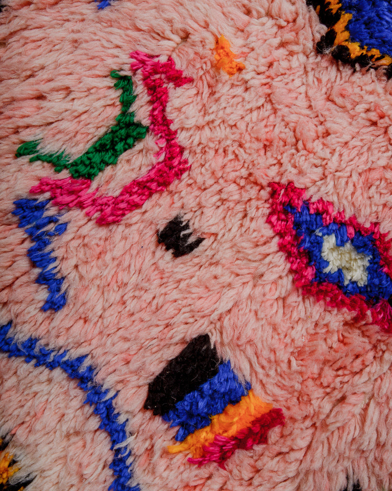 Surface of rug with colourful cotton in  pink, orange, blue, black and green.