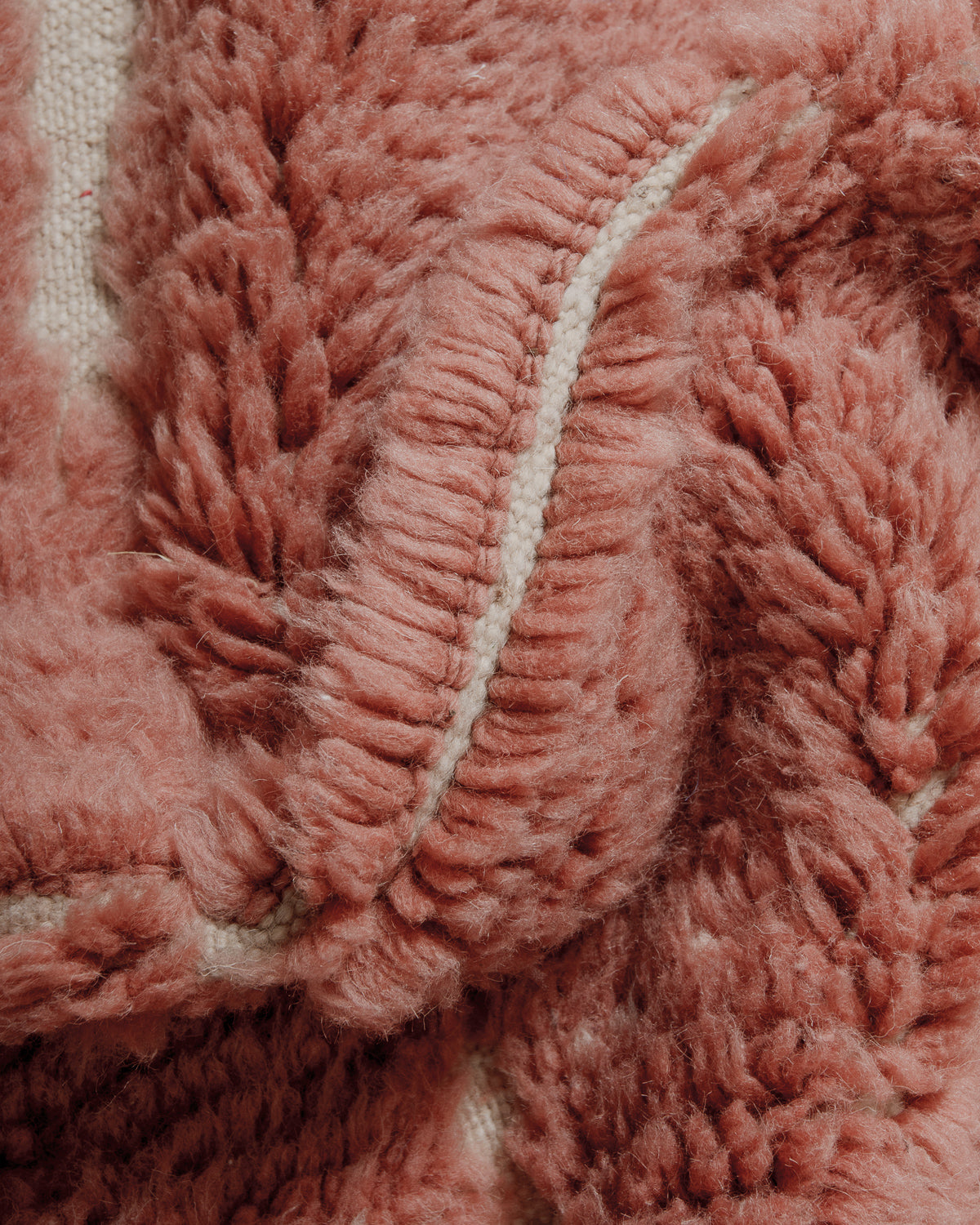 Detail of the thick pile of a rose coloured wool Berberlin Finest rug.