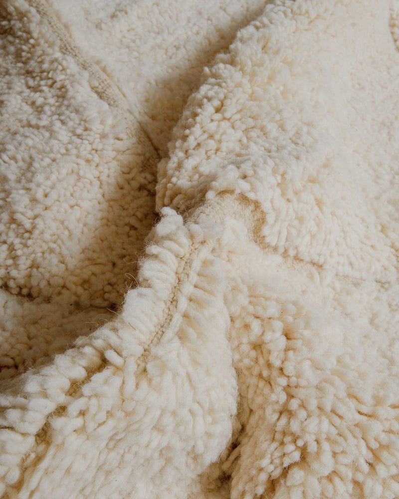 Close up of cream wool rug.