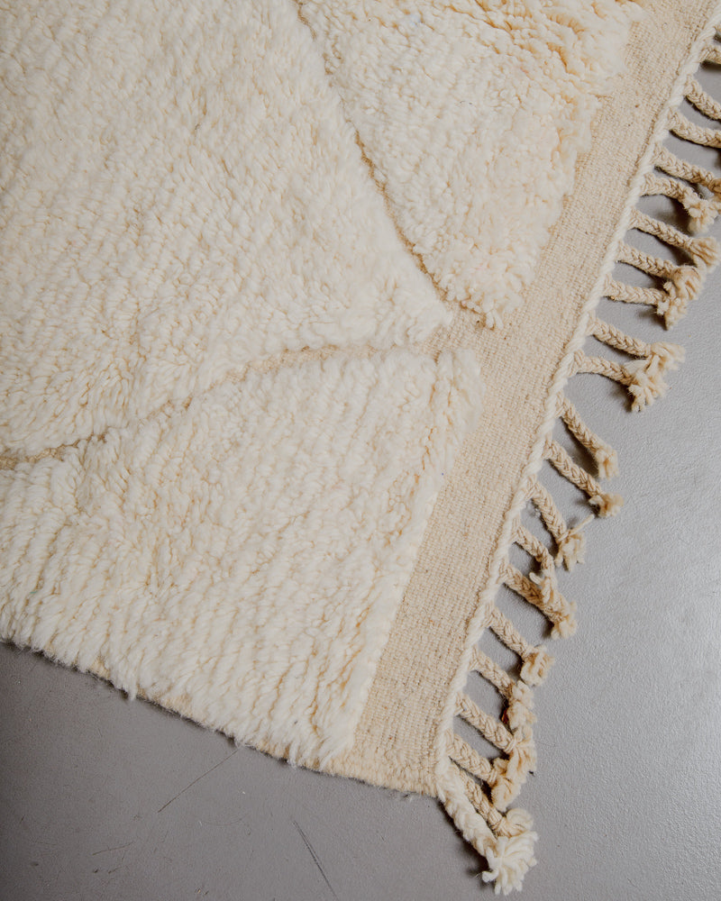 Corner of wool rug with natural tassels.