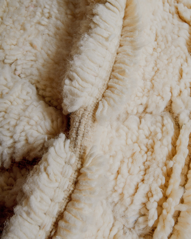 Close up of cream wool rug.
