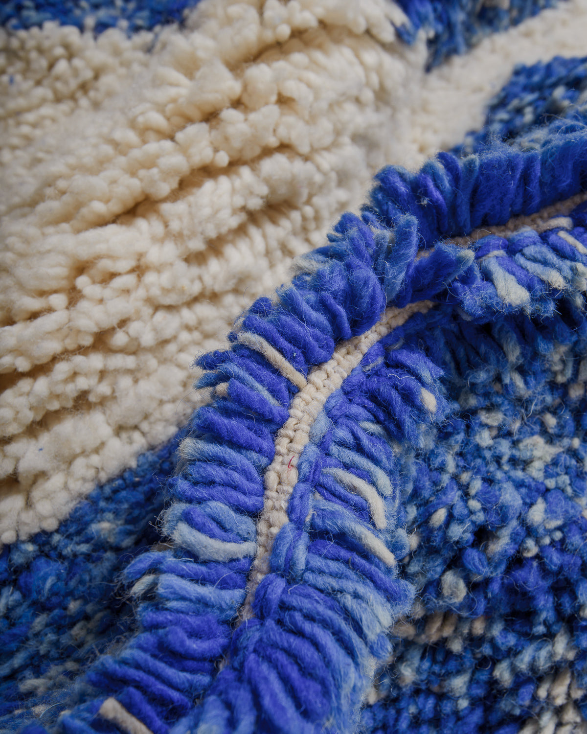 Close-up of wool rug with thick pile in blue and cream.
