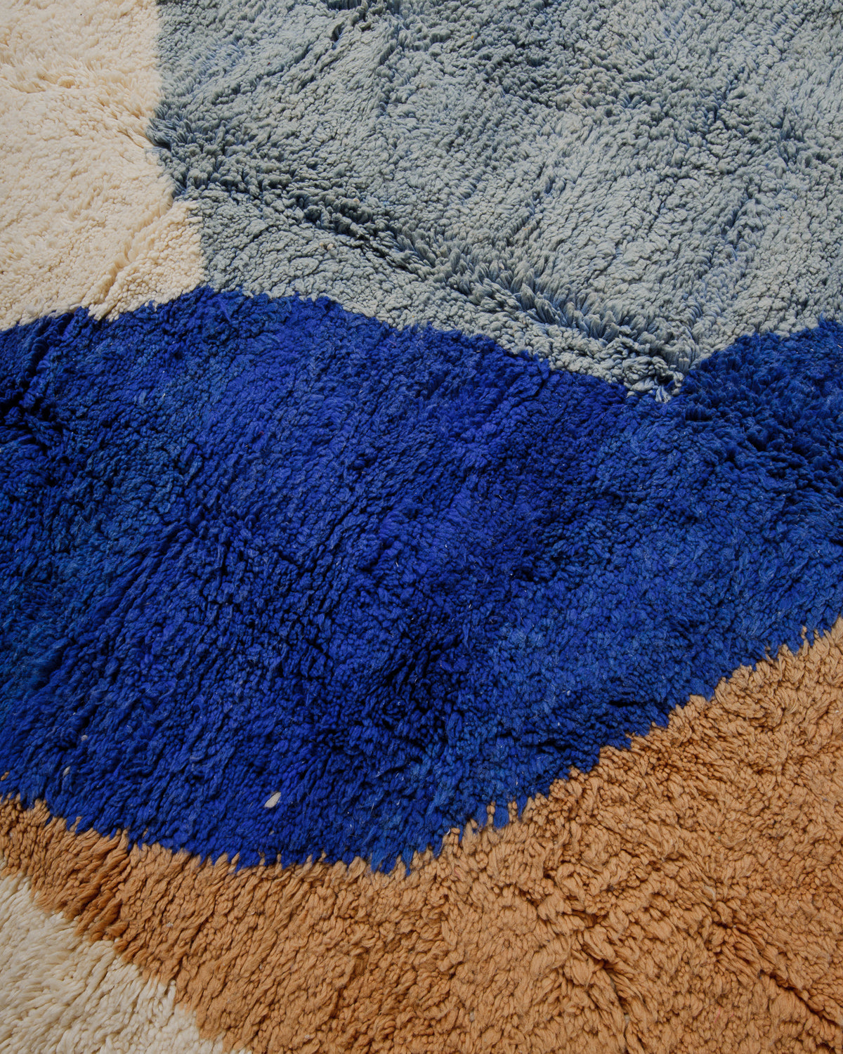 Close-up of a wool rug with blue, beige, and brown colours.