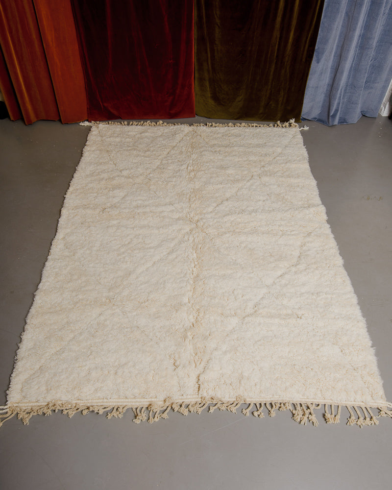 Berberlin Beniourain rug in cream wool on grey floor.