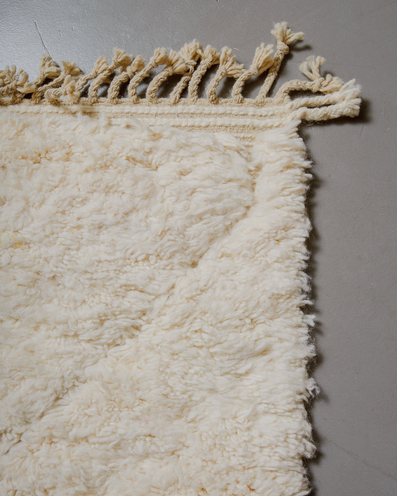 Corner of wool rug with natural tassels.