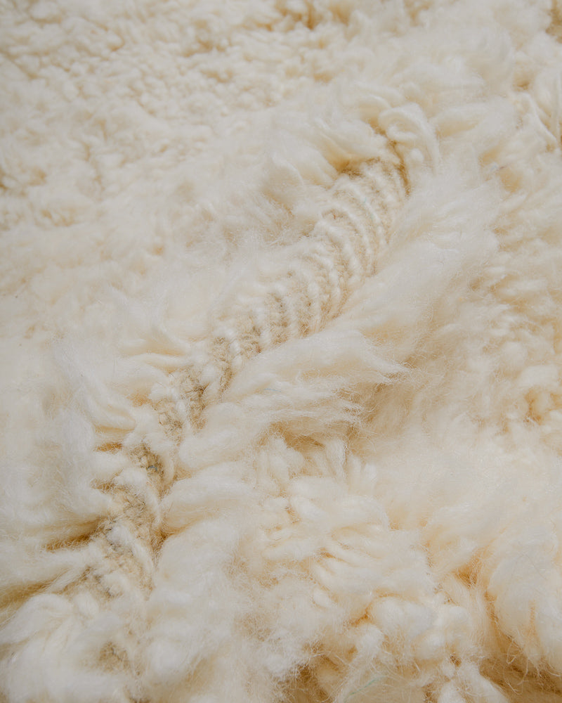 Close up of cream wool rug.