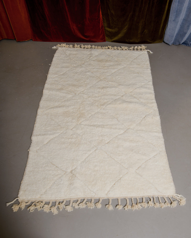 Berberlin Beniourain rug in cream wool on grey floor.