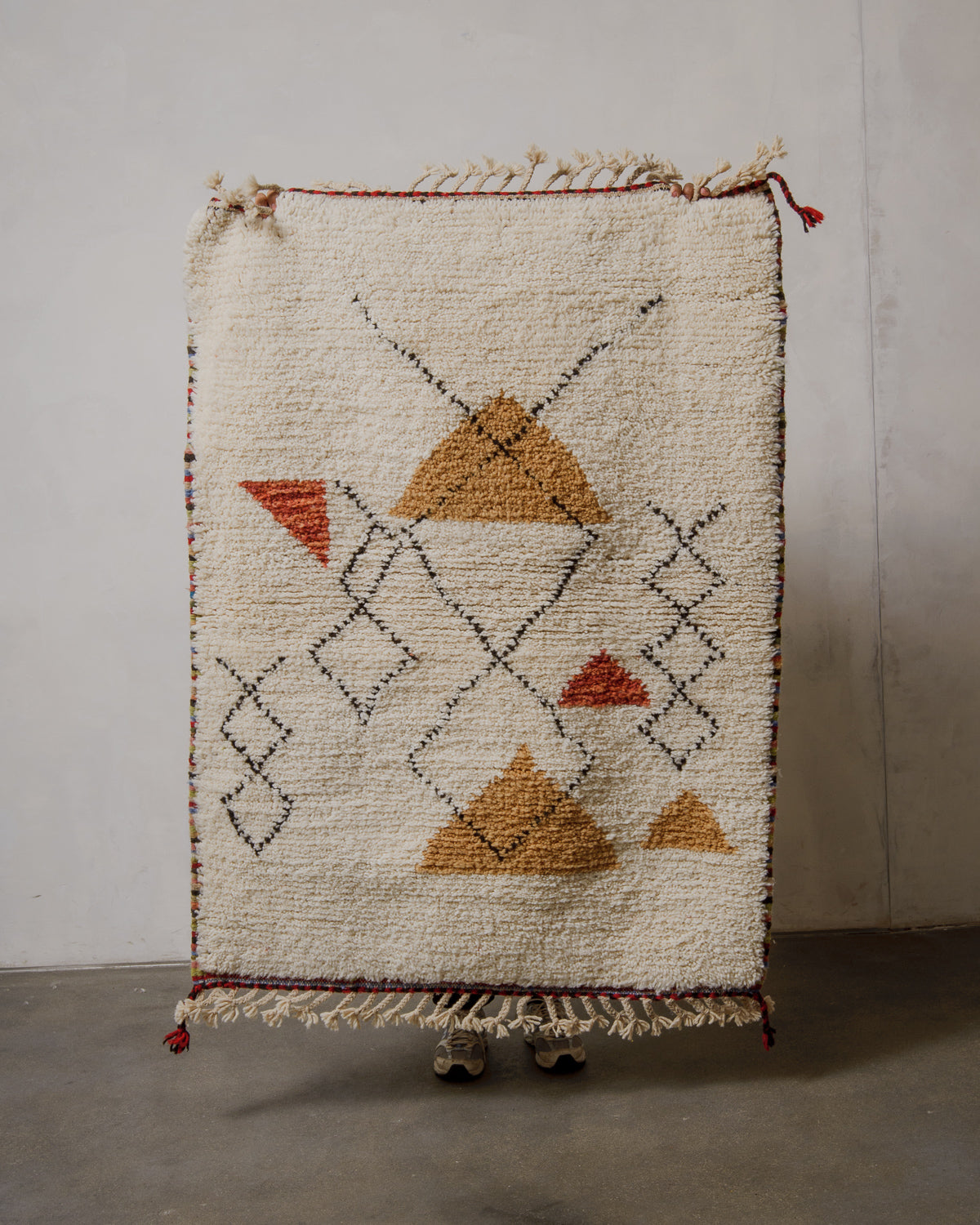 Geometric patterned rug with triangles on a plain background