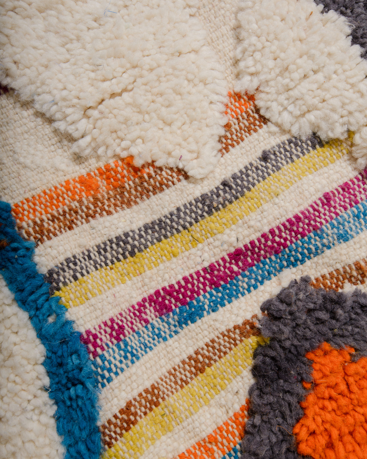 Close-up of a colorful woven rug with multicolor stripes.