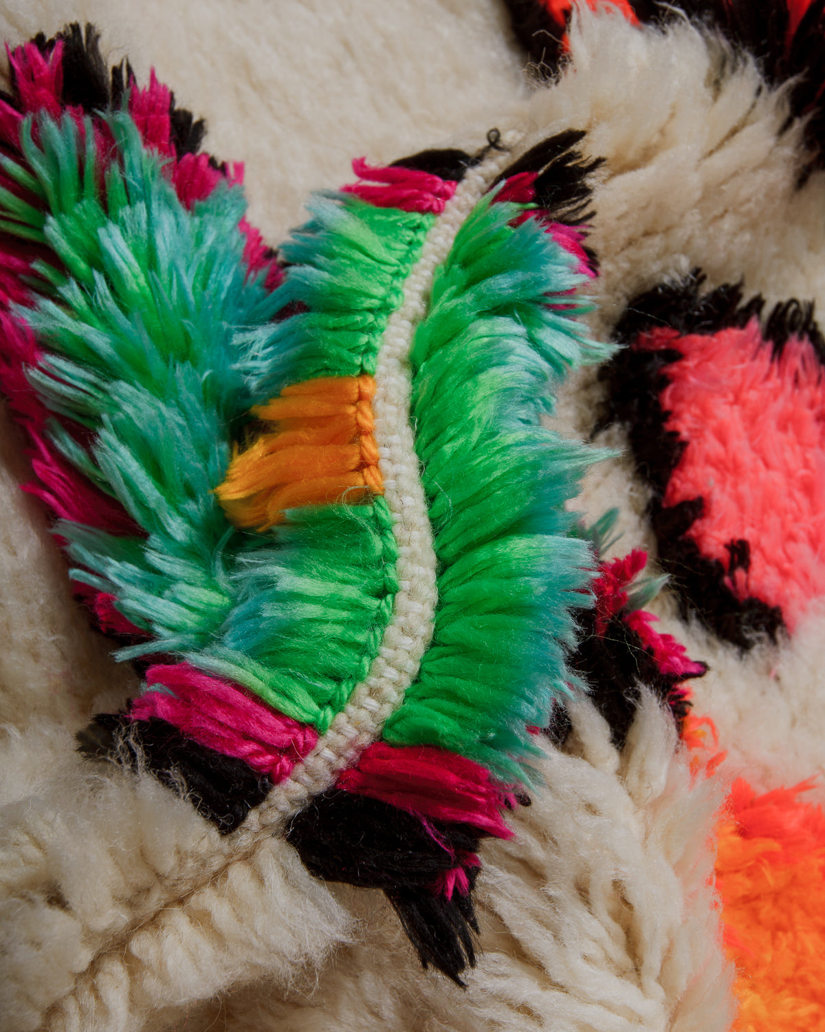 Close-up of a colorful yarn and cream wool rug.