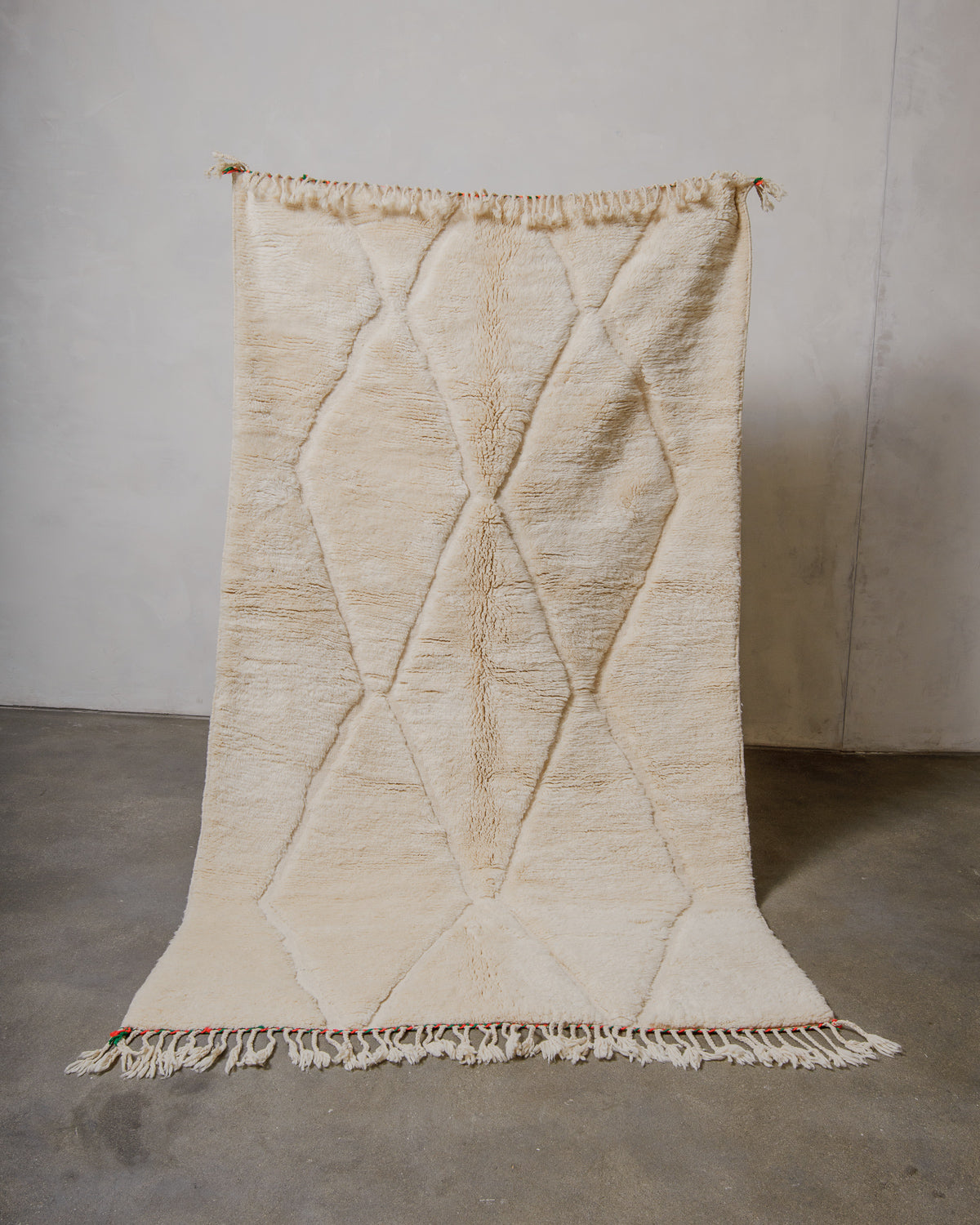 Cream wool rug with geometric pattern on a plain background