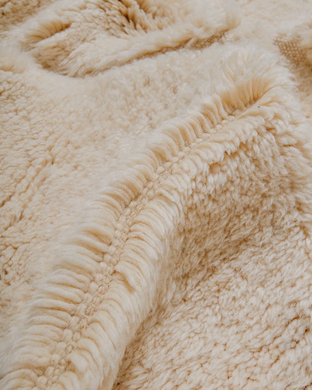 Close-up of cream wool rug with plush pile.
