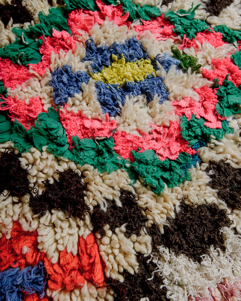 Close up of boucherouite rug with colourful cotton and fabric remnants and cream wool.
