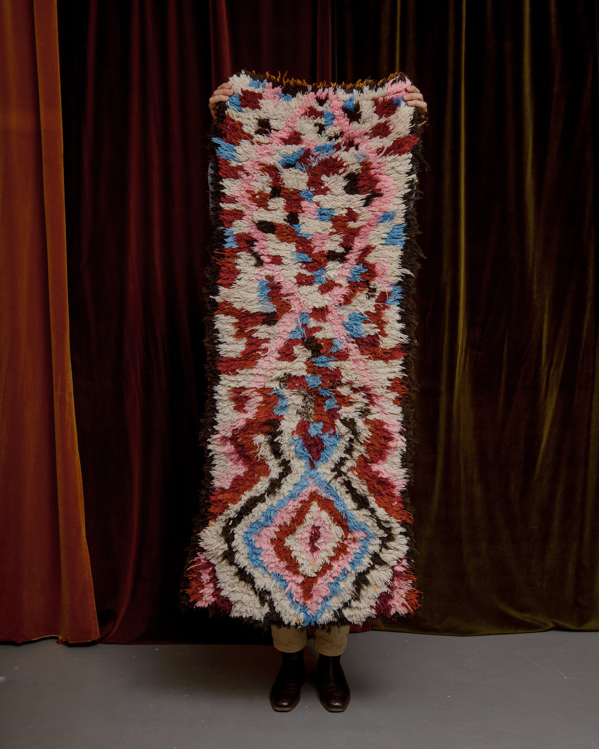 Boucherouite Runner held up in front of curtains.