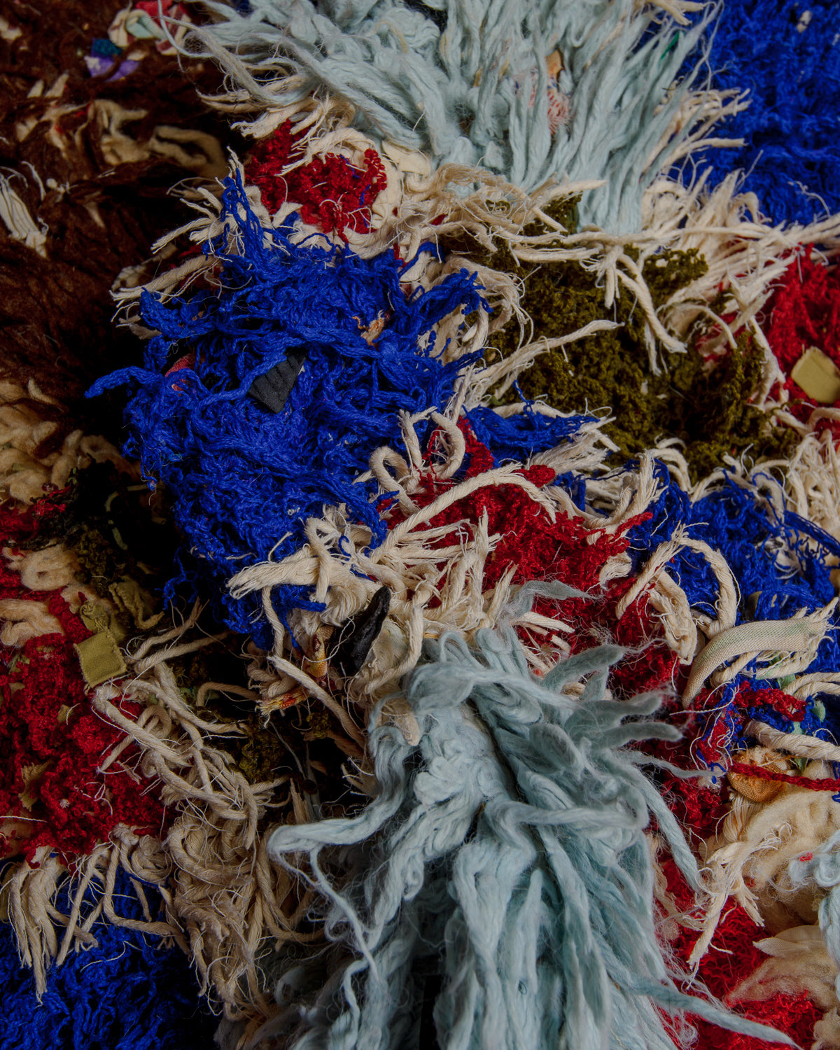 Close up of boucherouite rug with textured cotton and fabric remnants.