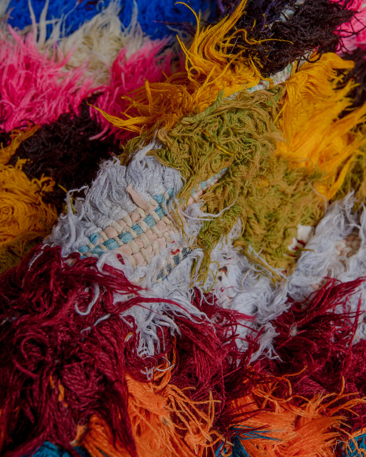 Close up of boucherouite rug with colourful cotton and fabric remnants.