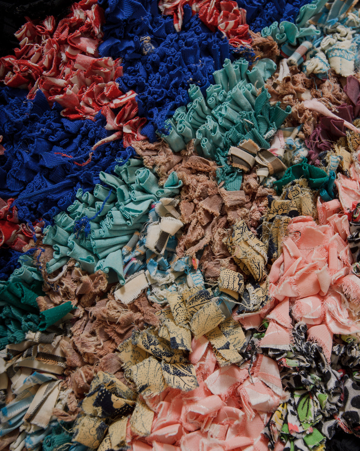 Close-up of colorful fabric scraps of  a boucherouite rug  in various patterns and colors.