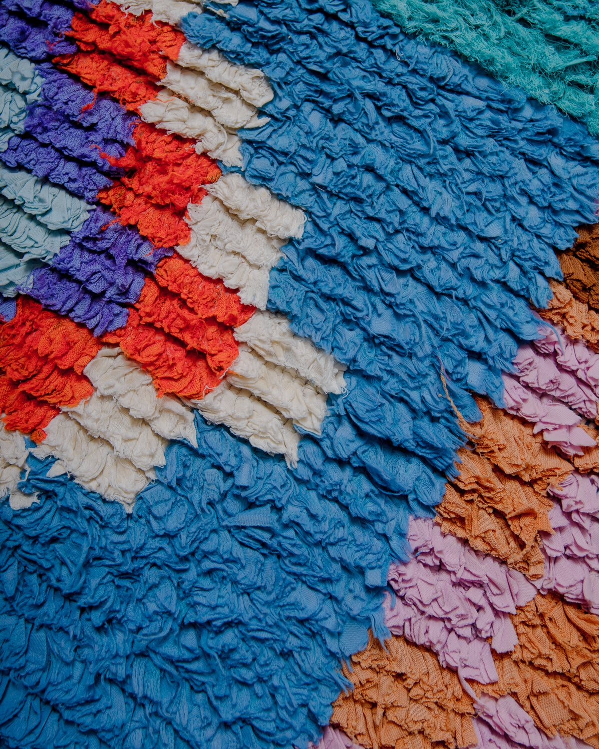 Close up of boucherouite rug with colourful cotton and fabric remnants.