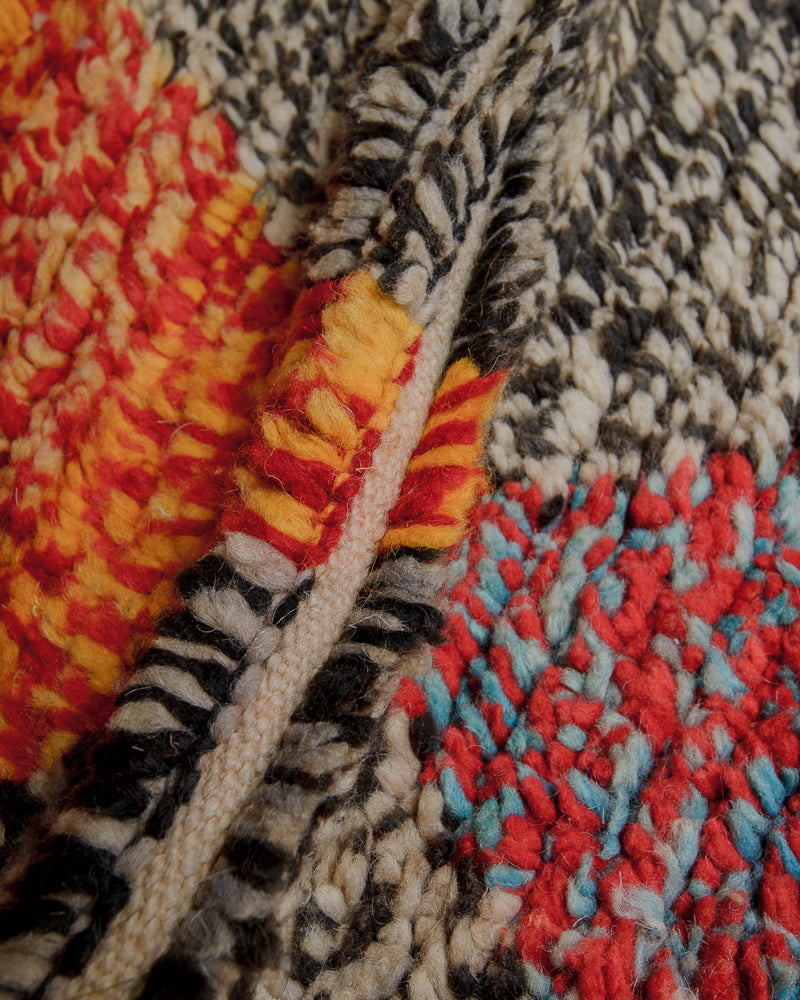 Close up of vintage wool rug showing density of wool pile and speckled colours.