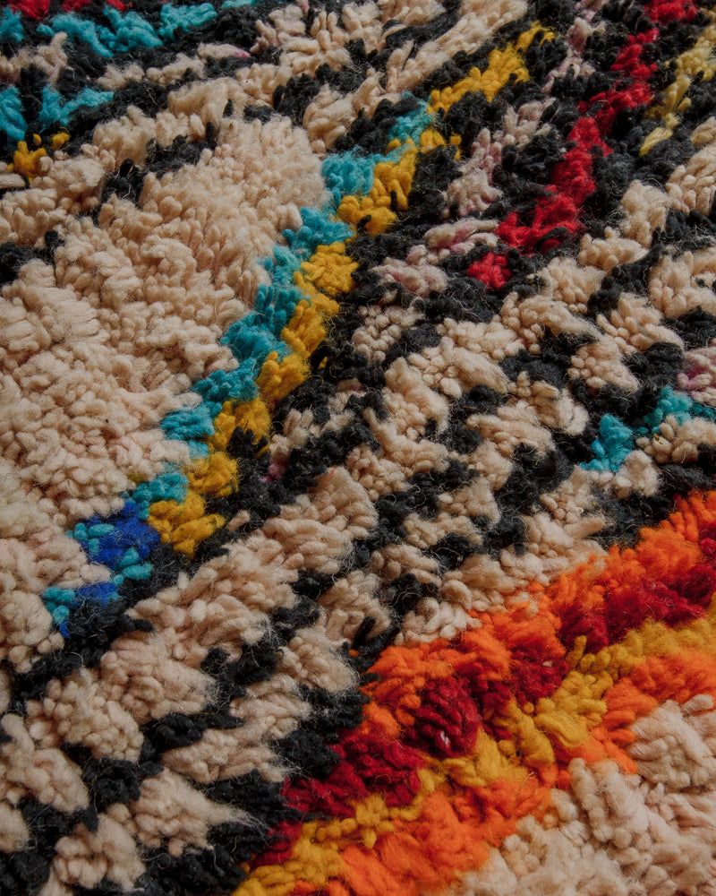 Surface of vintage wool rug with soft salmon, black, orange and blue. 