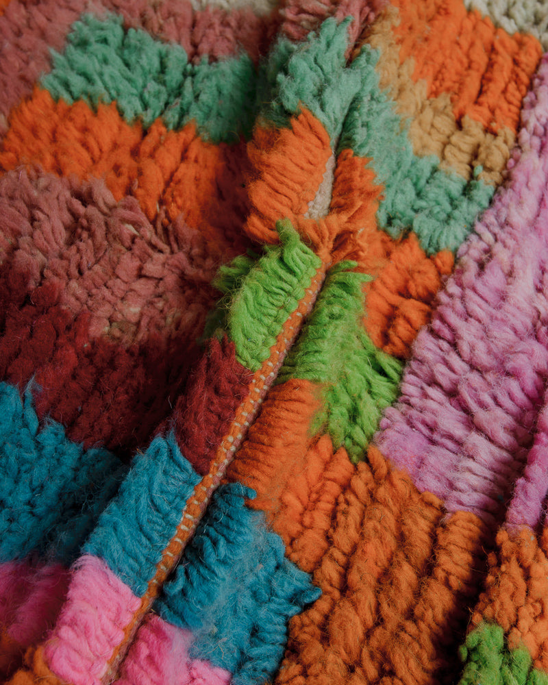 Close up of wool rug showing colourful, thick pile.
