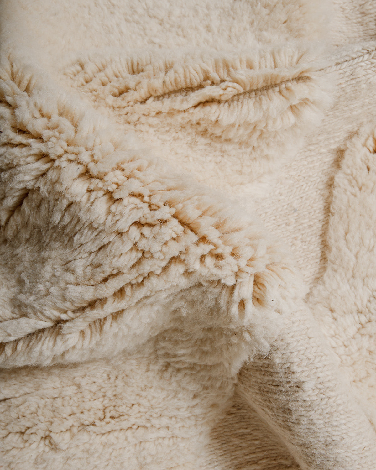 Close-up of textured surface of cream wool rug
