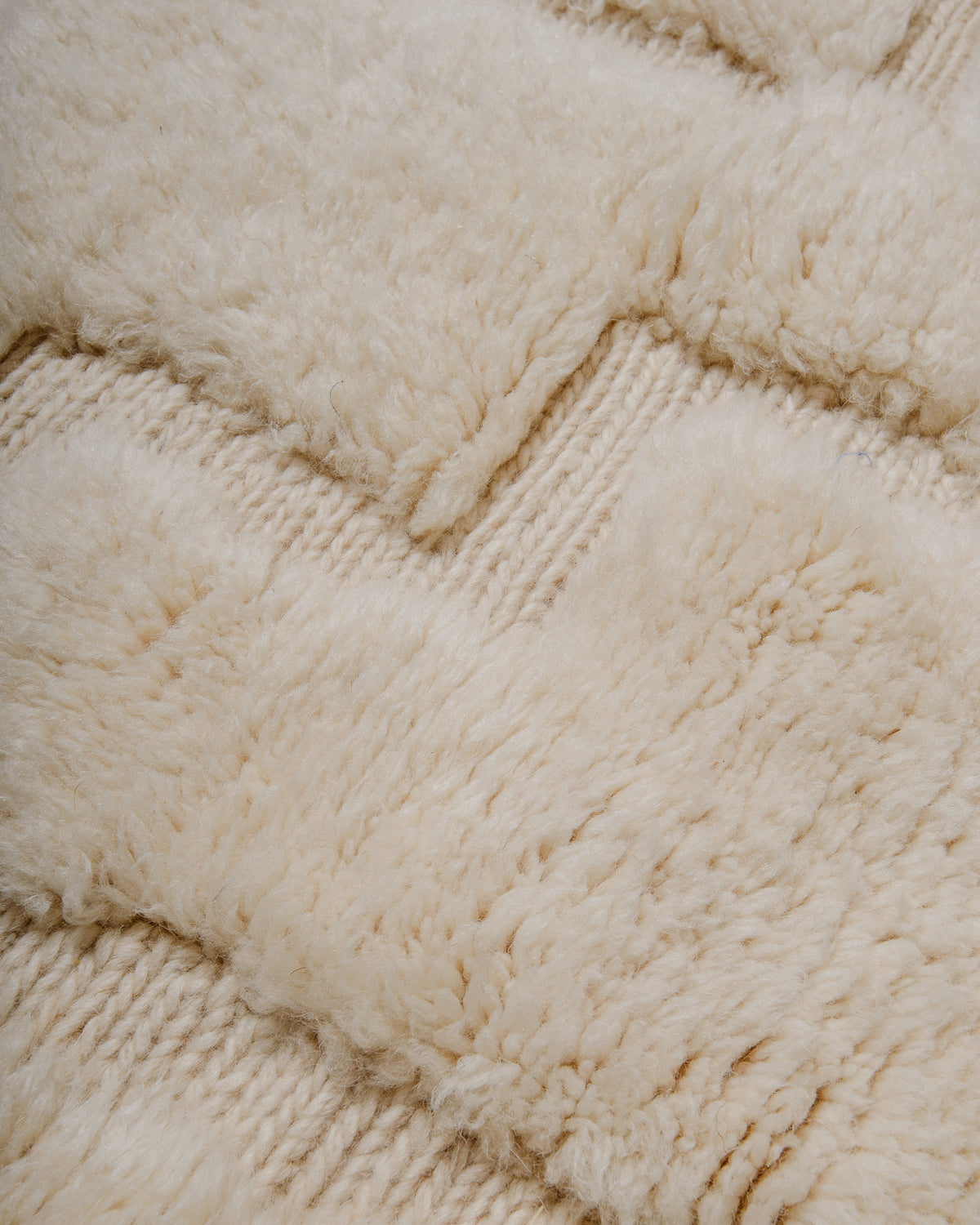 Close-up of textured cream wool rug with a woven pattern