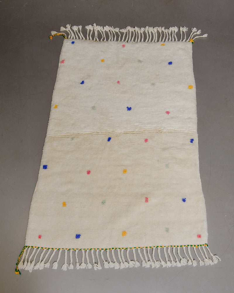 Berberlin Finest dotted rug on grey floor.