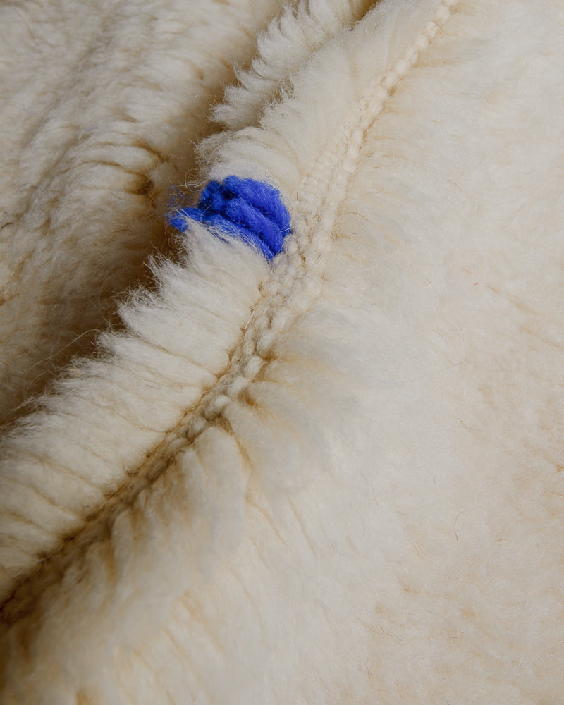 Close up of Berberlin Finest rug showing fluffy pile made of cream wool and blue wool detail.