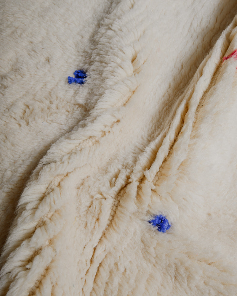 Close up of Berberlin Finest rug showing fluffy pile made of cream wool and blue wool details.