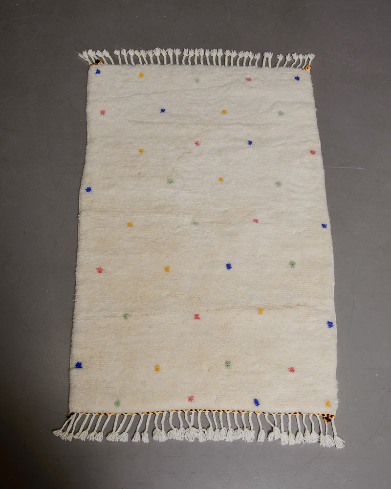 Berberlin Finest dotted rug on grey floor.