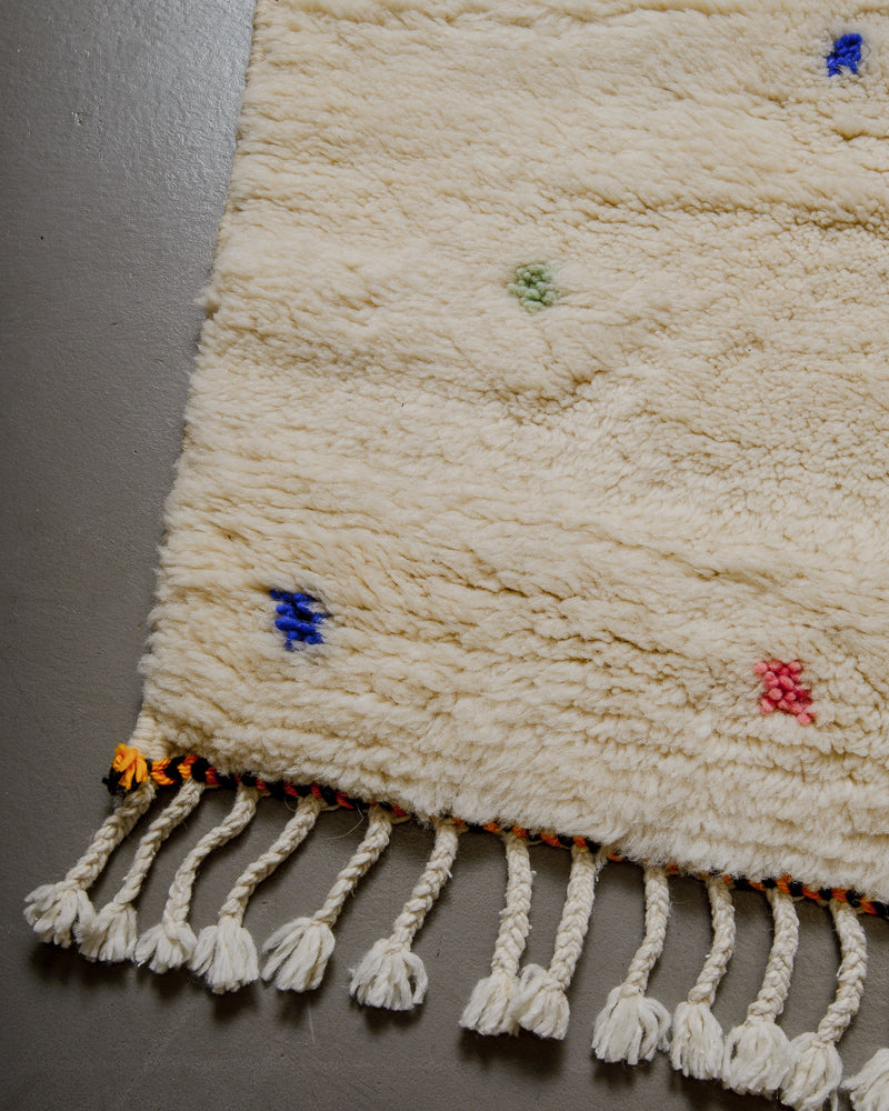 Edge of Berberlin finest rug with black and yellow trim and natural wool tassels. 