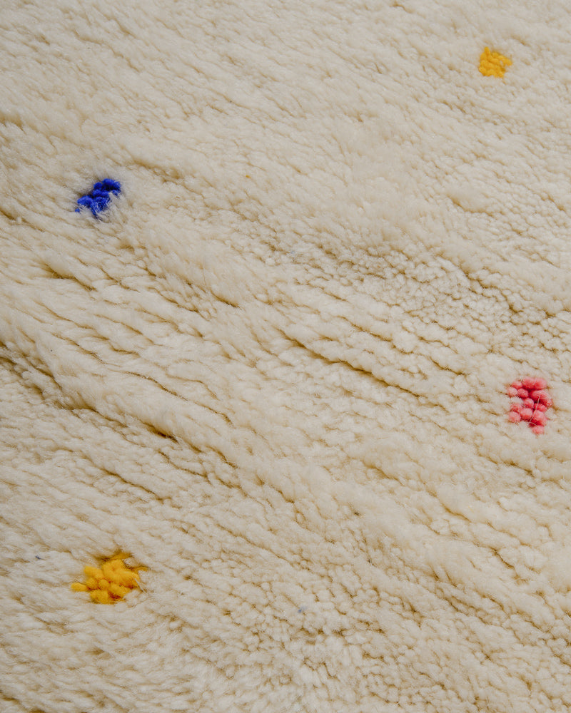Surface of Berberlin Finest rug with cream wool and colourful dots.