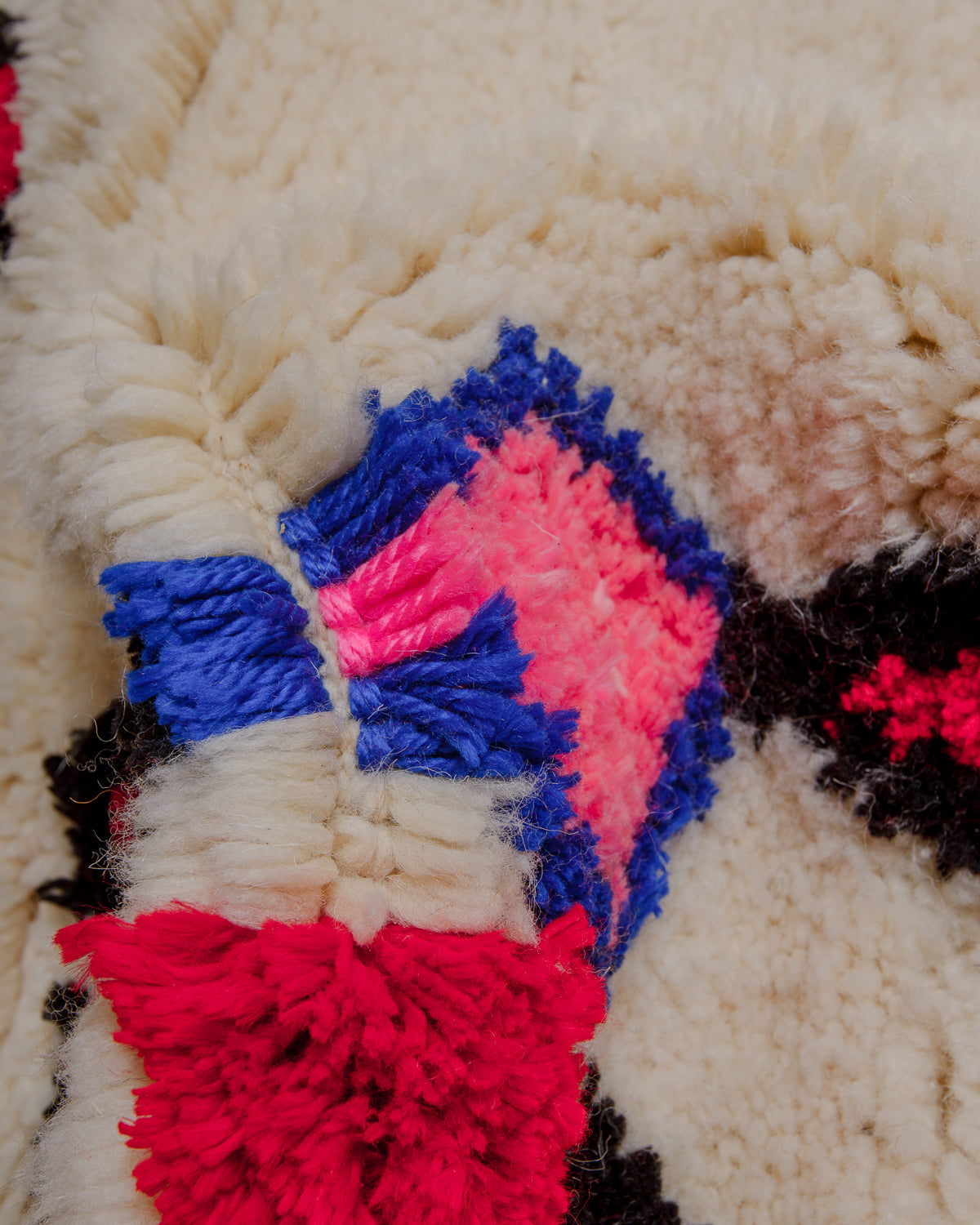 Close-up of a thick wool rug with highlights in soft cotton.