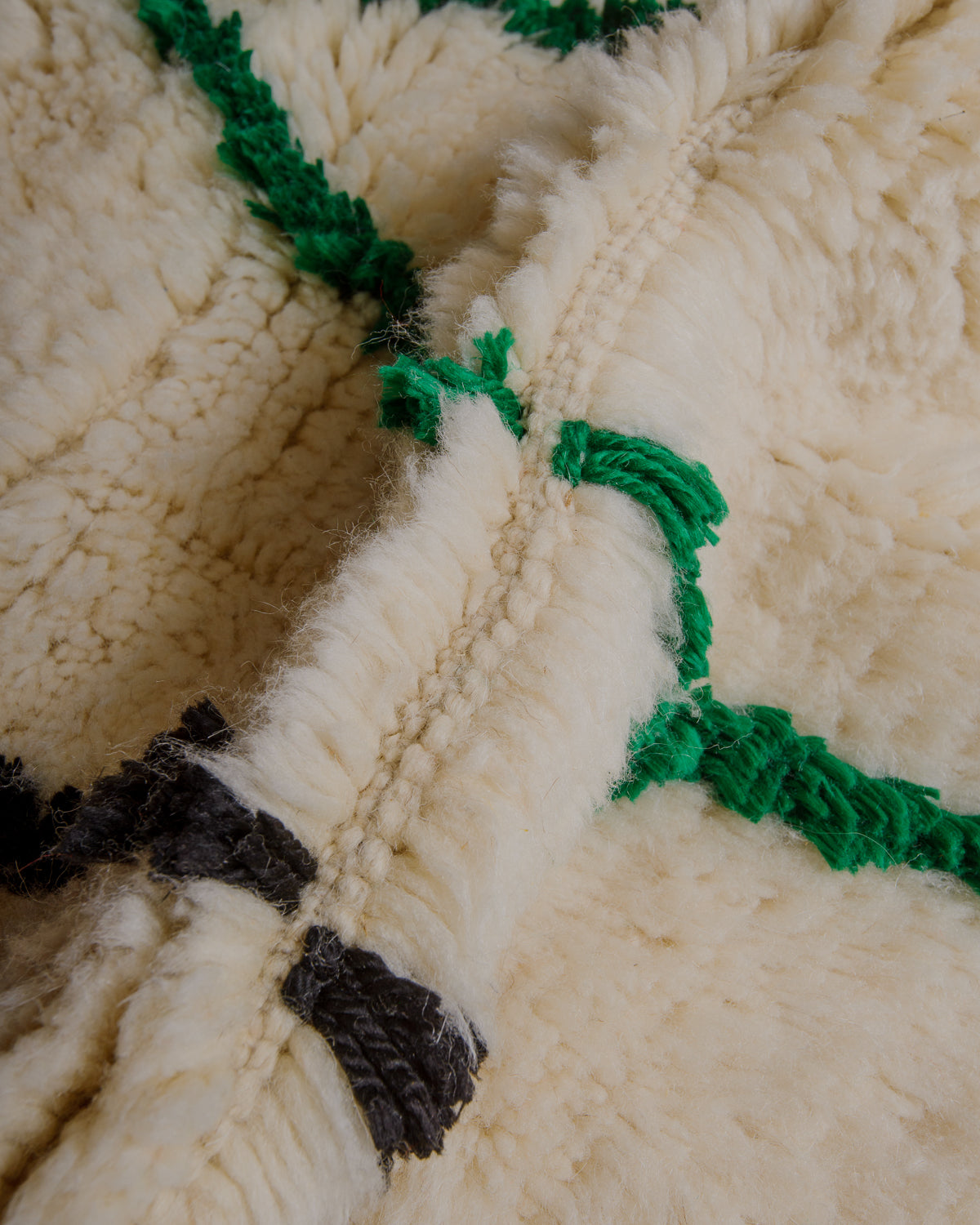 Close-up of a thick wool rug with highlights in soft cotton.