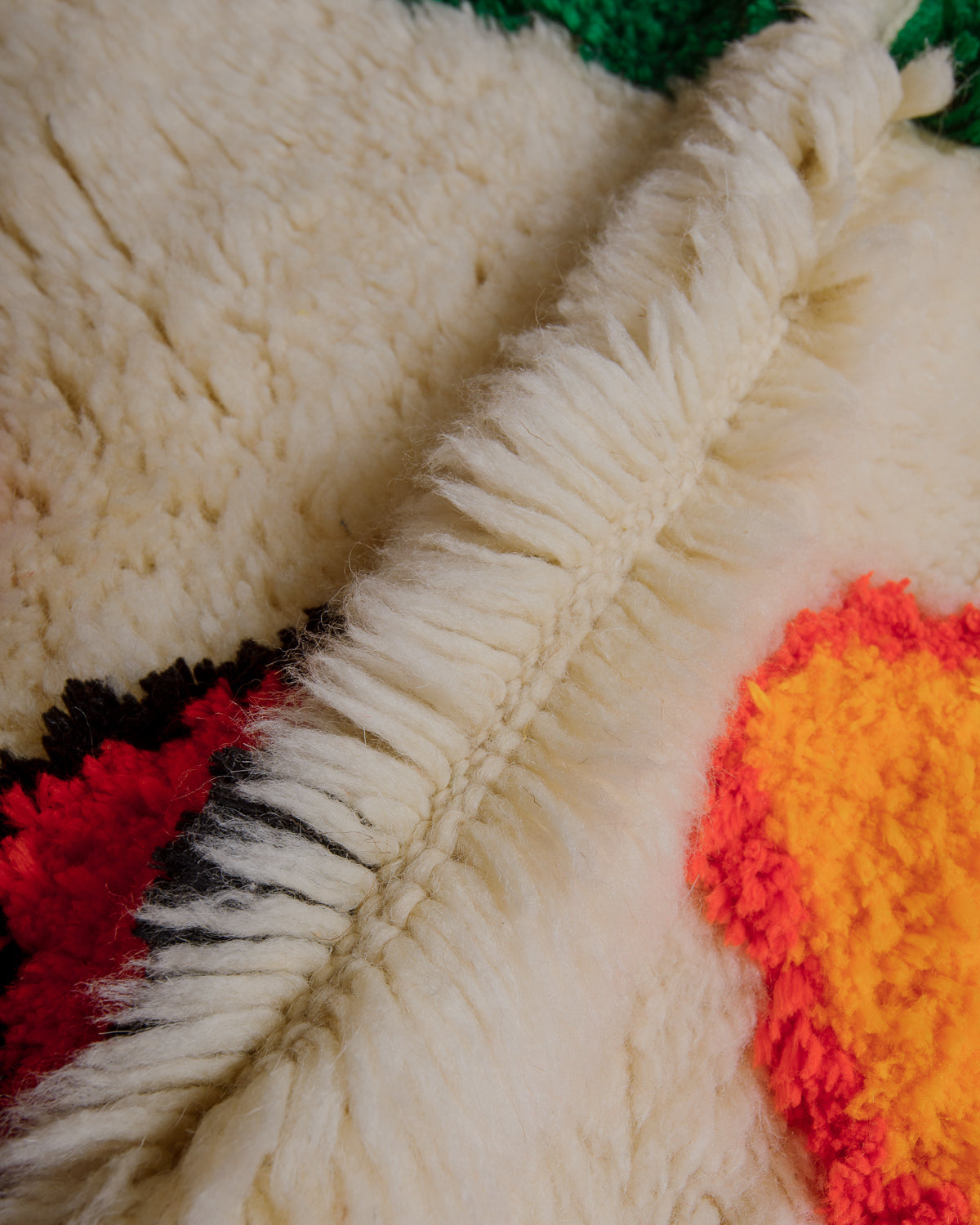 Close-up of a thick wool rug with highlights in soft cotton.