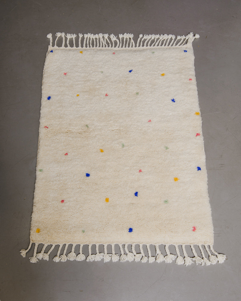 Berberlin Finest dotted rug on grey floor.