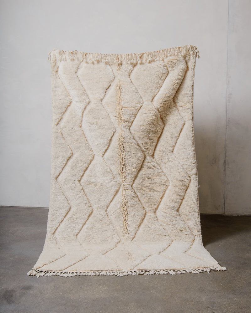 Cream wool rug with geometric pattern on a plain background