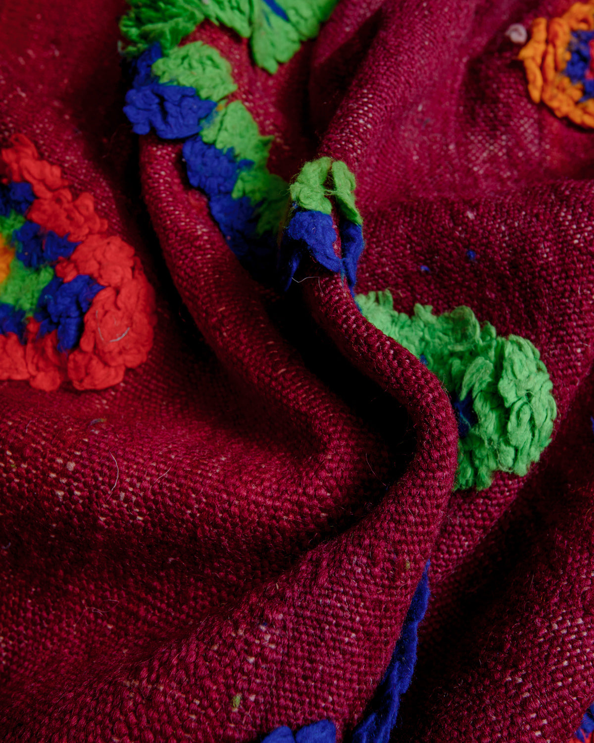 Close up showing the embroidered, raised details on the surface of the rug.