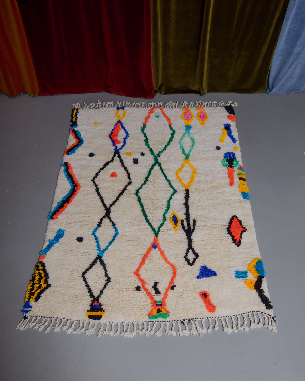 Berberlin Finest rug with a heavy cream pile and colourful design in cotton on a grey floor.