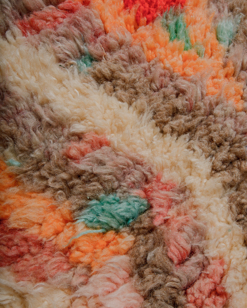 Close-up of a fluffy wool rug with multicoloured yarns
