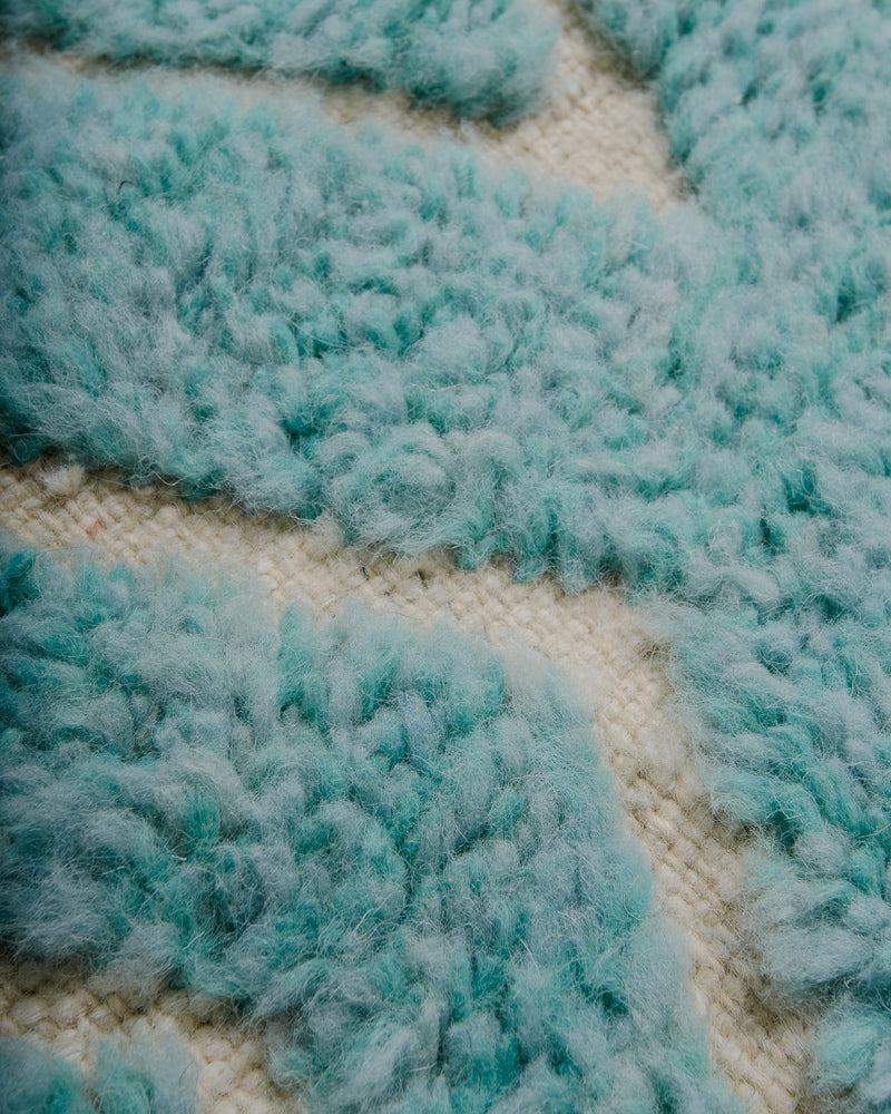 Close-up of a textured turquoise and beige fabric pattern
