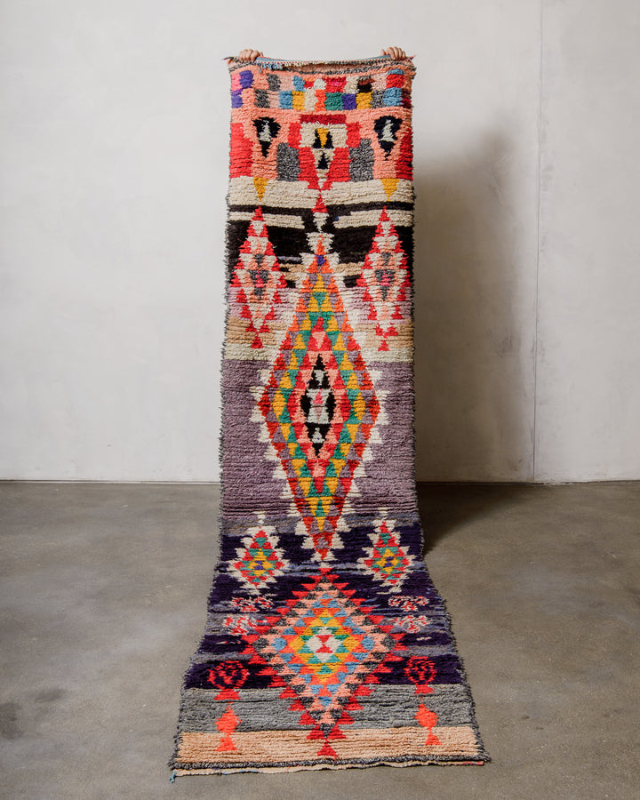 Colourful patterned rug on a plain floor with a neutral wall background