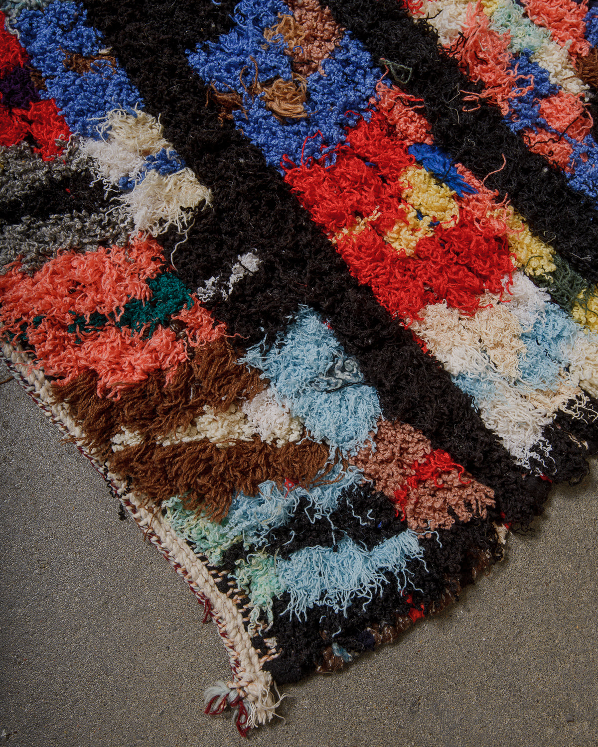 Multicolored textured rug on a concrete floor