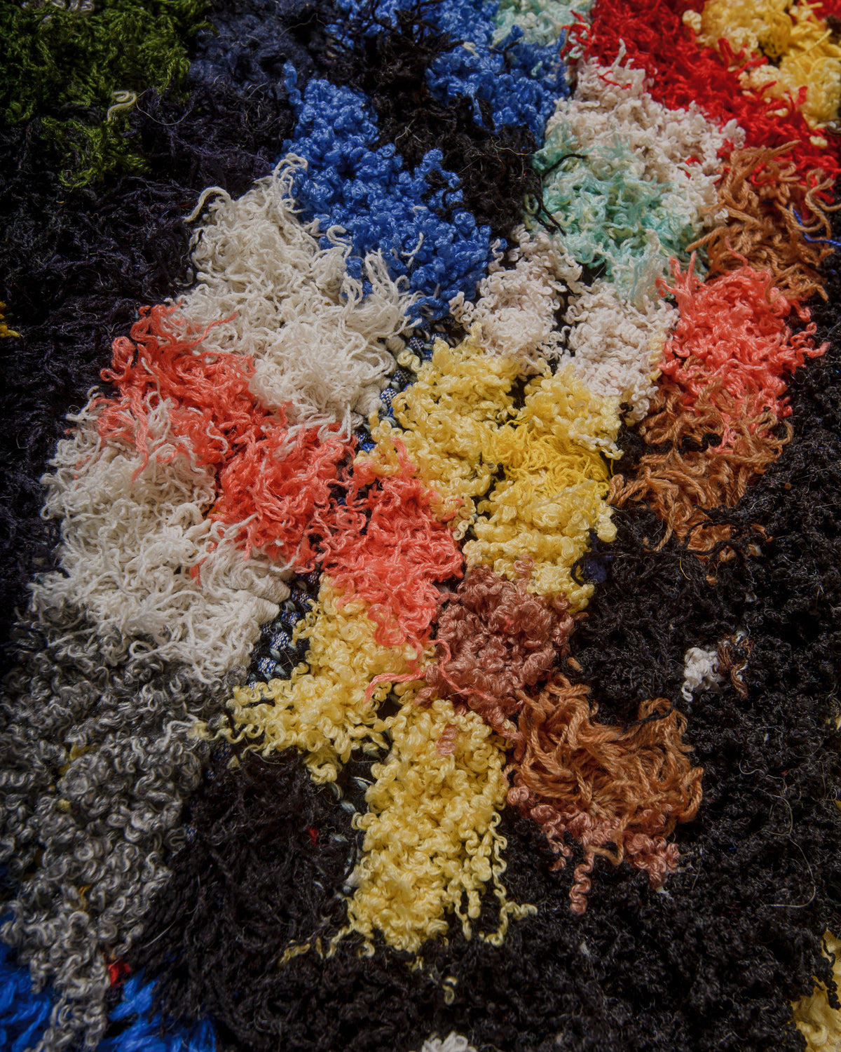 Close-up of a Berberlin boucherouite rug with multicolored yarn patterns.