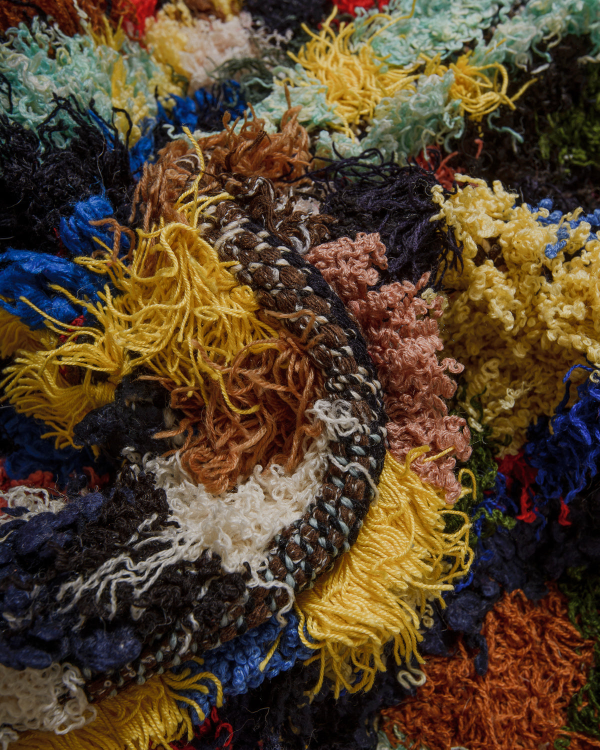 Close-up of a Berberlin boucherouite rug with multicolored yarn patterns.